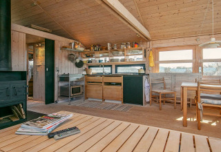 Accogliente cucina in legno e zona pranzo di chalet per 4 persone a Bindslev, Danimarca, con vista panoramica.