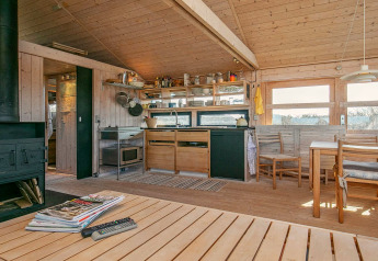 Gemütliche Ferienhausküche und Essbereich aus Holz für 4 Personen in Bindslev, Dänemark, mit Naturblick.