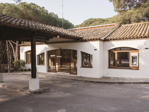 Ingang van Wecamp Cala Montgó vakantiepark in Catalonië, Spanje, omgeven door pijnbomen en natuur.
