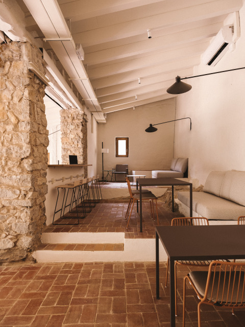 Interior elegante con paredes de piedra y muebles modernos en Wecamp Cala Montgó, en Cataluña, España.
