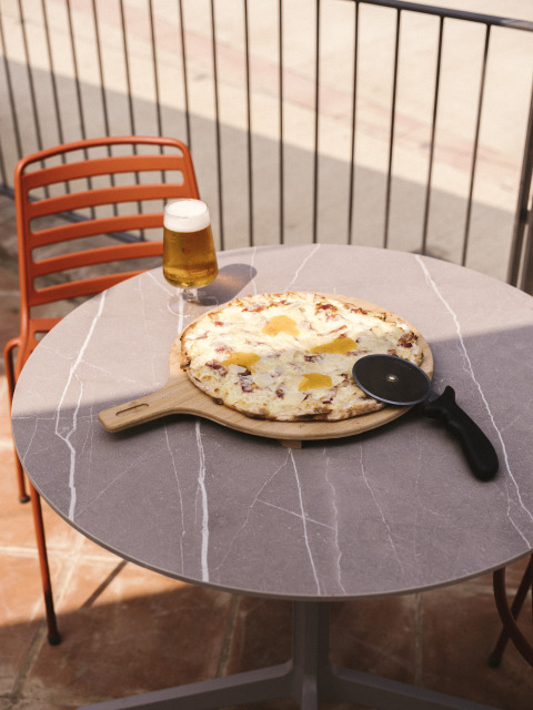 Pizza en bier op een buitentafel bij Wecamp Cala Montgó vakantiepark in Catalonië, Spanje.
