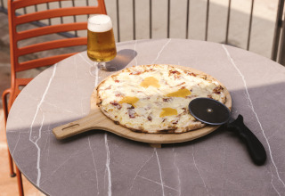 Pizza et bière sur une table extérieure au parc de vacances Wecamp Cala Montgó, en Catalogne, Espagne.