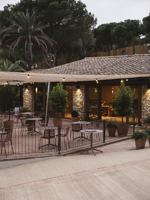 Terrasse extérieure du parc de vacances Wecamp Cala Montgó en Catalogne, Espagne, avec tables et chaises.