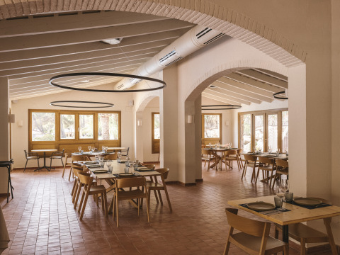 Helles, modernes Restaurant im Wecamp Cala Montgó Ferienpark in Katalonien, mit Holzmöbeln und großen Fenstern.
