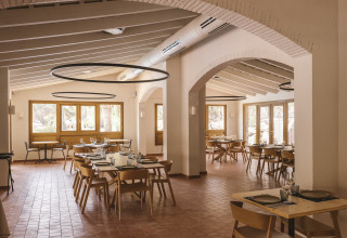 Interno luminoso e moderno di un ristorante presso Wecamp Cala Montgó, villaggio vacanze in Catalogna, con arredi in legno.