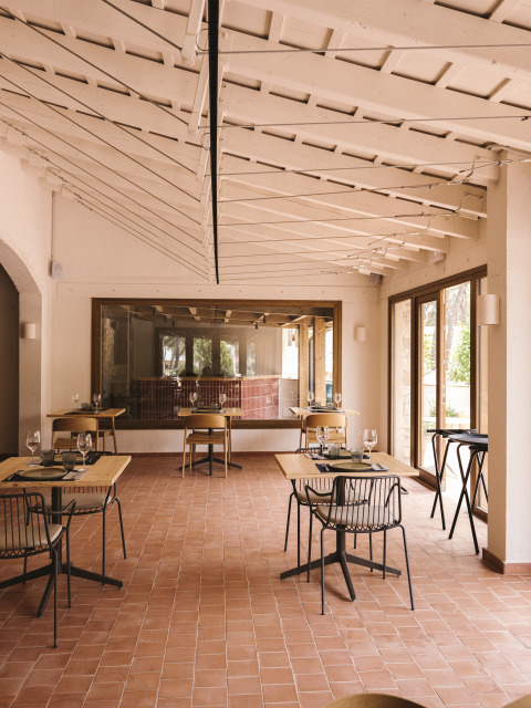 Lichte, moderne eetruimte in vakantiepark Wecamp Cala Montgó in Catalonië, Spanje met tegelvloer en glaswanden.