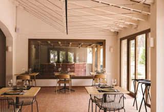 Salle à manger lumineuse et moderne au parc de vacances Wecamp Cala Montgó en Catalogne, Espagne avec sol en carrelage.
