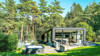 Modern 8-person holiday home in Ebeltoft with large windows, outdoor hot tub and a forest backdrop.