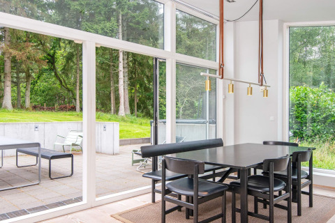 Essbereich in modernem Ferienhaus in Ebeltoft, Dänemark, mit großen Fenstern und Naturblick.