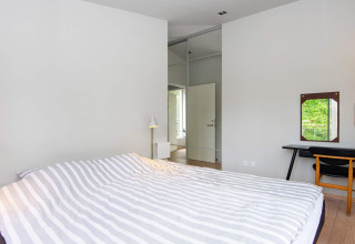 Schlafzimmer im 8-Personen-Ferienhaus in Ebeltoft, Dänemark, mit modernem Design und Gartenblick.