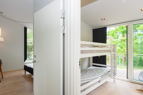 Schlafzimmer mit Etagenbett und großen Fenstern im 8-Personen-Ferienhaus in Ebeltoft, Dänemark.