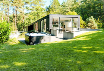 Casa vacanze moderna a Ebeltoft, Danimarca, con jacuzzi, grandi finestre e ambiente verde rigoglioso.