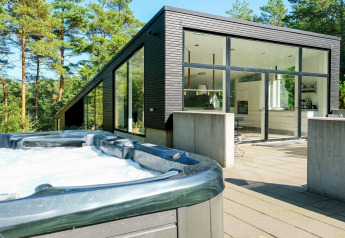 Modern vakantiehuis voor 8 personen in Ebeltoft, Denemarken, met buitenjacuzzi en grote ramen in het bos.