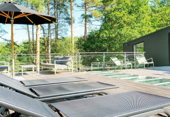 Ampio terrazzo soleggiato con lettini e ombrellone nella casa vacanze per 8 persone a Ebeltoft, Danimarca.