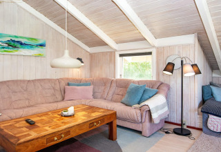 Gezellige woonkamer in de «Secluded Harbor Cottage» in Denemarken met hoekbank, houten tafel.