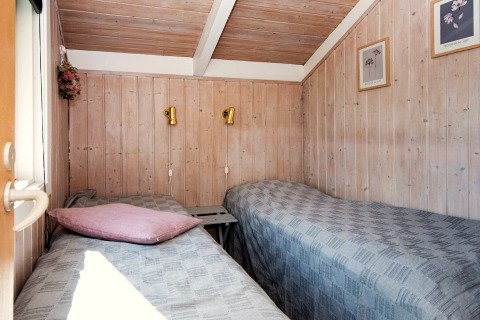 Heldere kamer met twee eenpersoonsbedden in Secluded Harbor Cottage, Denemarken; hout en wandkunst.