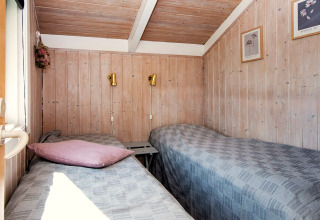 Heldere kamer met twee eenpersoonsbedden in Secluded Harbor Cottage, Denemarken; hout en wandkunst.