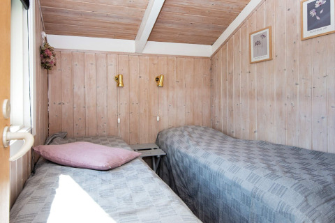 Heldere kamer met twee eenpersoonsbedden in Secluded Harbor Cottage, Denemarken; hout en wandkunst.