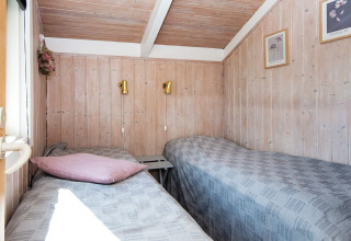Heldere kamer met twee eenpersoonsbedden in Secluded Harbor Cottage, Denemarken; hout en wandkunst.