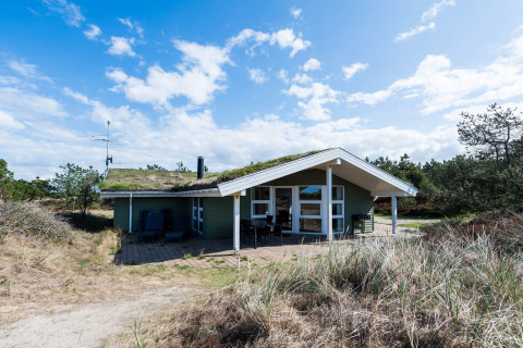 Außenansicht eines 6-Personen-Ferienhauses in Blåvand, Dänemark, inmitten von Natur und Dünen.