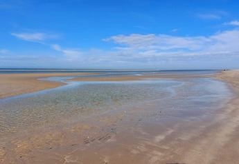 Plage à marée basse sous ciel bleu près d’une maison de vacances 6 personnes à Blåvand, Danemark.