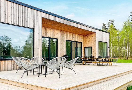 Udendørs terrasse på Cozy Sea House med moderne havemøbler og udsigt til skov og natur.