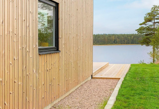 Udsigt til søen fra en lodge ved navn 'Cozy Sea House with Guest Cottage' i Sverige med træfacade.