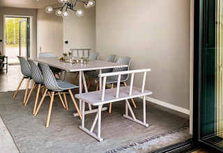 Spisestue i moderne lodge ved navn Cozy Sea House med stilfulde stole, bænk og store vinduer i Sverige.