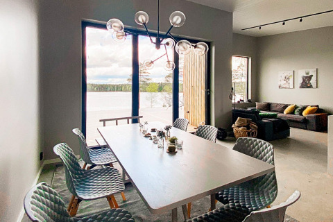 Moderne spisestue i Cozy Sea House med udsigt til søen, luksuriøse stole og hyggelig stue, Sverige.