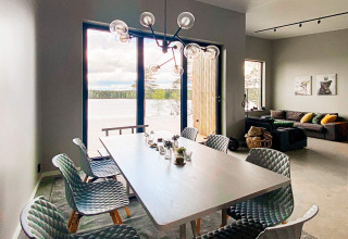 Moderne spisestue i Cozy Sea House med udsigt til søen, luksuriøse stole og hyggelig stue, Sverige.