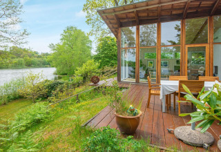 Vista terrazza della casa vacanze per 6 persone a Bryrup, Danimarca, con grandi finestre e vicino al lago.