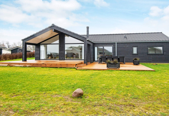 Vista esterna della casa vacanze per 8 persone a Sydals con rivestimento in legno nero e ampia terrazza.