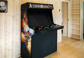 Grand borne d'arcade rétro avec illustration Street Fighter II dans un gîte à Sæby, Danemark.