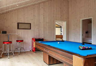 Spielzimmer im Ferienhaus in Sæby, Dänemark, mit Billardtisch, Barhockern und Coca-Cola-Kühlschrank.