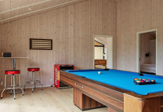Spielzimmer im Ferienhaus in Sæby, Dänemark, mit Billardtisch, Barhockern und Coca-Cola-Kühlschrank.
