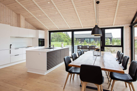 Cucina e zona pranzo moderne in casa vacanze per 10 persone a Sæby, Danimarca, con grandi finestre.