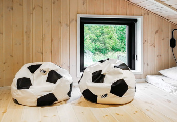 Twee voetbal zitzakken in een lichte kamer van hout bij het raam in het 10 persoons vakantiehuis in Sæby, Denemarken.