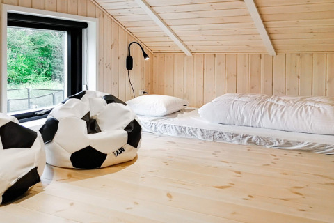 Habitación tipo loft en casa de vacaciones para 10 personas en Sæby, Dinamarca, con pufs de fútbol y colchones.