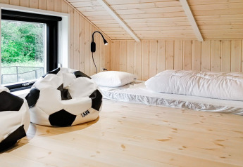 Zolderkamer in 10-persoons vakantiehuis in Sæby, Denemarken met voetbal-zitzakken en matrassen op de vloer.