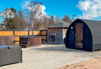 Espace extérieur du gîte 10 personnes à Sæby, Danemark, avec sauna, bain chaud et salon de jardin.