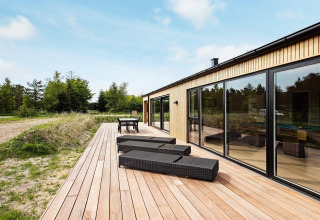 Terrasse extérieure d'une maison de vacances 10 personnes à Sæby, Danemark, avec transats et table en pleine nature.