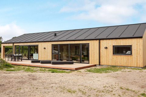 Maison de vacances moderne à Sæby, Danemark, avec façade en bois, grande terrasse et toit noir pour 10 personnes.