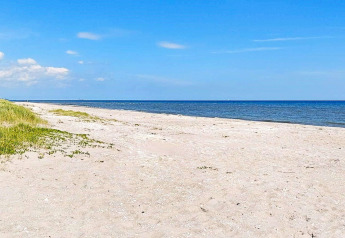 Vue ensoleillée sur une plage paisible et la mer calme près de Sæby, Danemark, depuis le gîte de vacances.