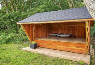 Udendørs træly ved Cozy Coastal Cottage Retreat i Danmark med to liggestole og tæt på skovområde.