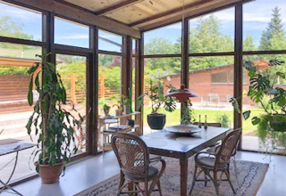 Soleada zona de comedor en casa vacacional para 6 personas en Bryrup, Dinamarca, con ventanales y plantas.