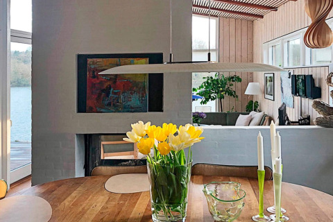 Eethoek in een vakantiehuis in Bryrup, Denemarken, met tulpen en zicht op het meer buiten.