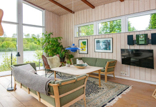 Bright, modern living room in a Bryrup holiday home, Denmark, featuring large windows and lush views.
