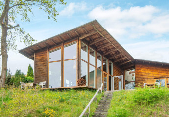 Außenansicht eines 6-Personen-Ferienhauses in Bryrup mit großen Fenstern und schöner Naturumgebung.