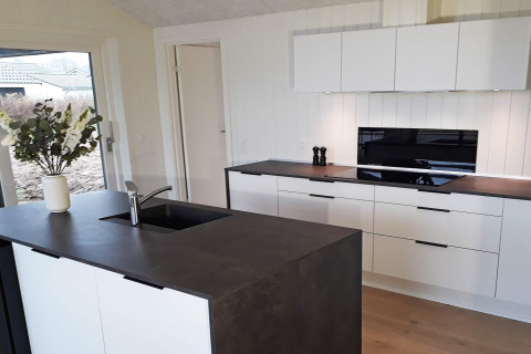 Modern kitchen in an 8-person holiday home in Sydals, Denmark, with white cabinets and dark countertops.