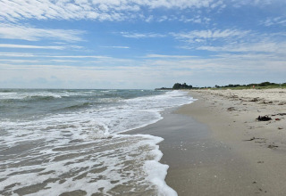Coastal view from 8 person holiday home in Sydals, Denmark, showing sandy beach and ocean waves.